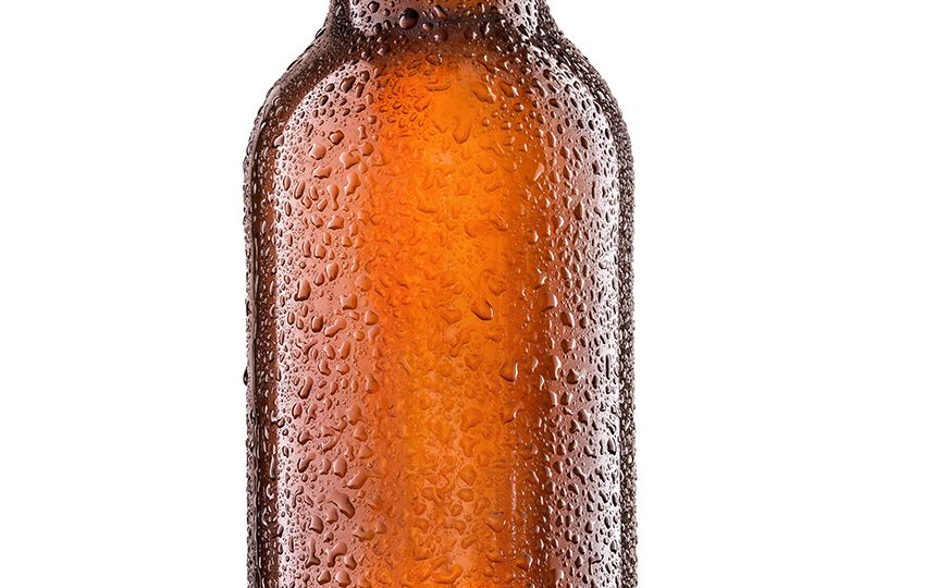 Bottle of beer with drops on white background.